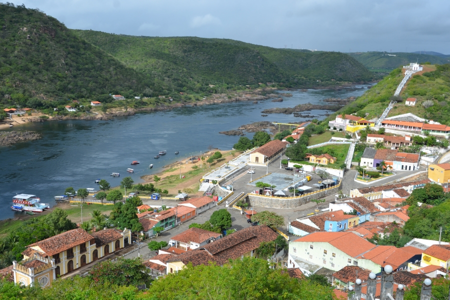 Vista panorâmica de um grande rio com uma pequena cidade histórica à sua margem direita