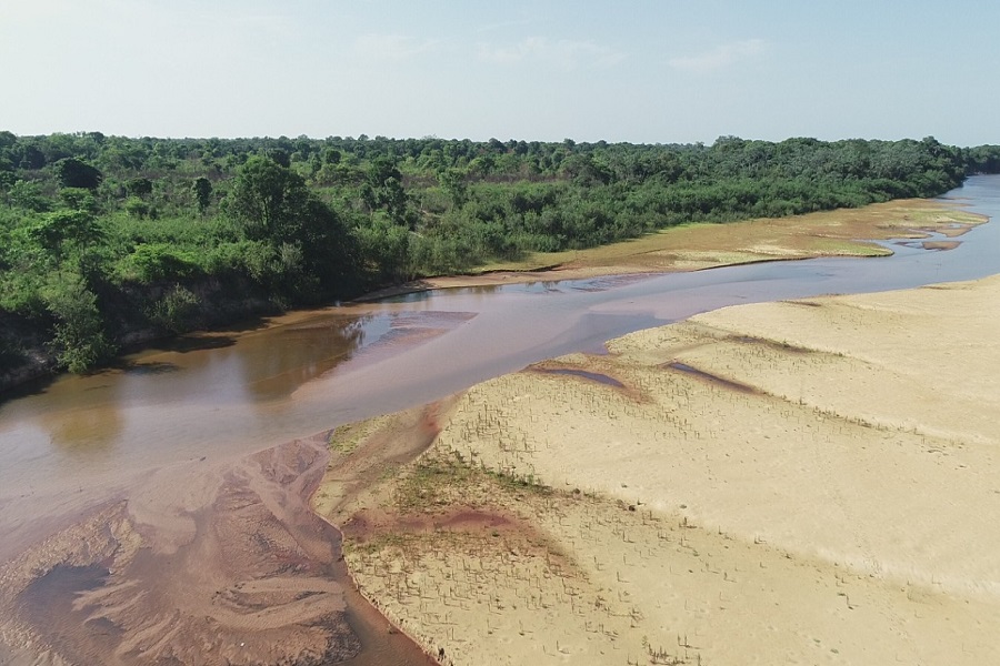 Foto colorida do Rio Formoso, no Tocantins, na margem esquerda vegetação nativa, verdejante, e à direita uma praia fluvial de areia e vegetação rasteira