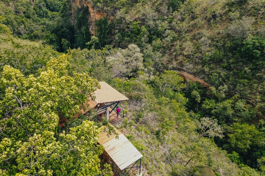 Imagem colorida de aérea de uma estrutura de madeira usada para observar um mirante em meio a fenda vegetação do Cerrado
