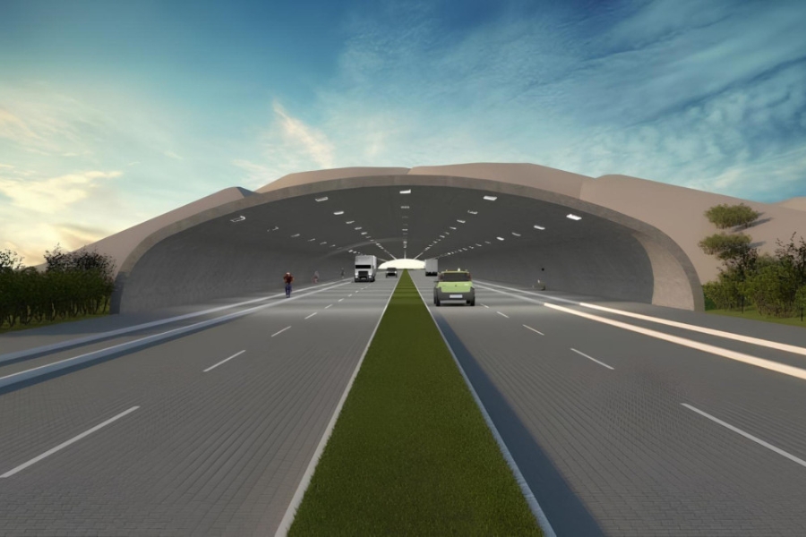 Ilustração digital de uma rodovia de pista dupla que atravessa um túnel largo e arqueado sob dunas. A via possui um canteiro central gramado e é percorrida por veículos, incluindo um caminhão branco e um carro pequeno, enquanto ciclistas utilizam as faixas laterais. O túnel de concreto é iluminado por fileiras de luzes embutidas no teto curvo, e as encostas de areia sobre a estrutura integram-se à paisagem litorânea, sugerindo uma solução arquitetônica para a livre circulação da fauna e preservação do ecossistema local. Ao fundo, o céu exibe tons suaves de azul e dourado