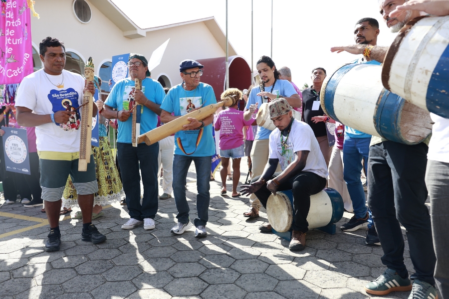 Grupo de homens toca tambores e instrumentos tradicionais ao ar livre